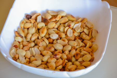 Peanuts fried in a white bowl. Close-up