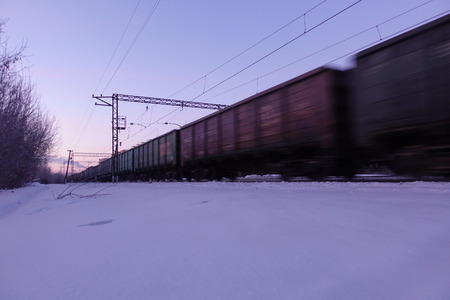 Freight train moves at high speed in winter after heavy snowfall. Partially slight motion blur. Russiaの写真素材