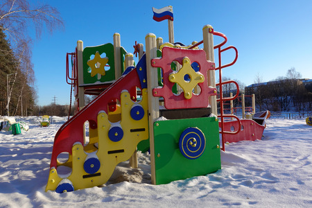 Empty playground for children on a frosty snowy winter day covered with snow without people. Russian playground. Maritime military theme. Raising children in the military spirit.の写真素材