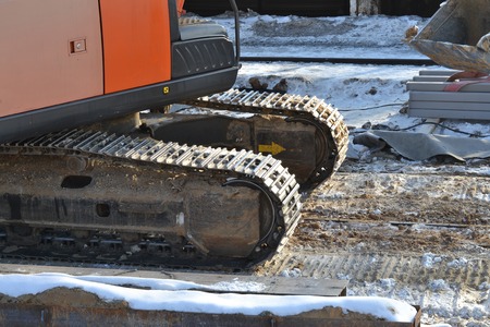 Closeup Continuous tracks or Tracked wheel of excavator or backhoe on the soil floor.