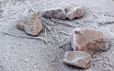 Stones on a wooden base covered with hoarfrost. Winter frosty background.の写真素材