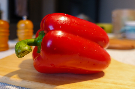 Large ripe Capsicum annuum or sweet red bell pepper on the white background close up. Vegetarian Concept. Organic vitamins.の写真素材
