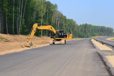 Crawler Excavator digging bucket on construction of high-speed bypass road. Heavy machine equipment...