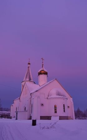 Winter frosty morning. The church is lit by pink and purple dawn colors. Russiaの写真素材