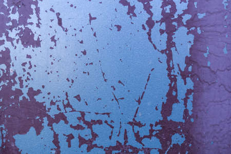 Old grungy shabby rusty metal with crumbling blue and purple paintの写真素材