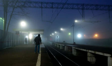 A train arrives at the railway station. Night, fog, Russia