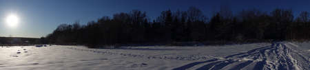 panoramic shot. Winter snow field with forest. Low winter sun. Russiaの写真素材