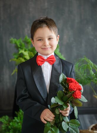 Young boy in black suit with red bow tieの写真素材
