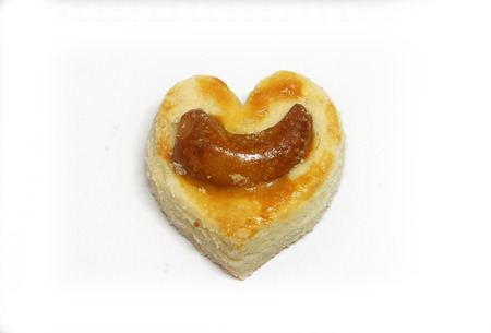 Heart shape cookies with cashew on top isolated on white backgroundの写真素材