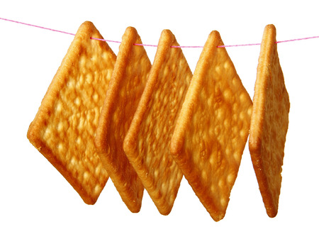 Hanging Salty Crackers are on white background.の写真素材