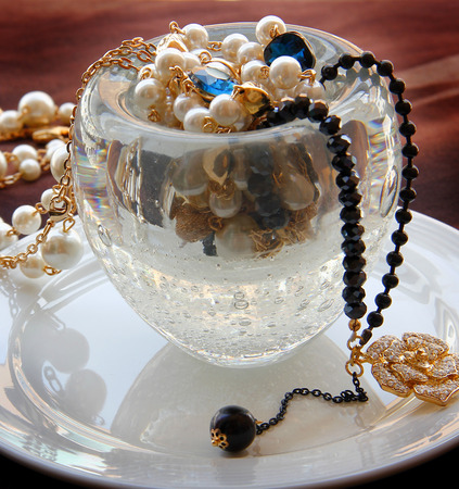 Pearl necklace and golden decoration in table ware.の写真素材