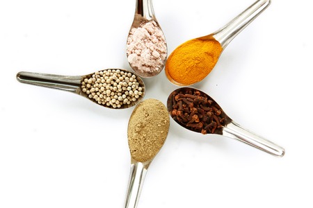 Spices. Spice and herbs in steel spoon isolated on white background.