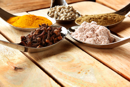 Spices. Spice and herbs in steel spoon are on wooden background.の写真素材