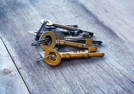 vintage golden keys are on woonden background.の写真素材