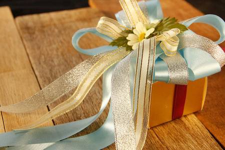 Elegance Golden Gift Box is on Wooden Background.の写真素材