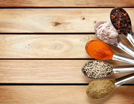 Spice and herbs in steel spoon are on wooden background. Displayed for the nutrients healthy banner.の写真素材