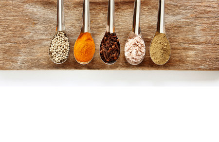 Spice and herbs in steel spoon are on wooden background. Displayed for the nutrients healthy banner.の写真素材
