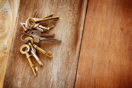 Vintage golden keys are on a wooden background for the mysterious, elegant vintage bannerの写真素材