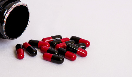 black-red pill spilled out of the boxの写真素材