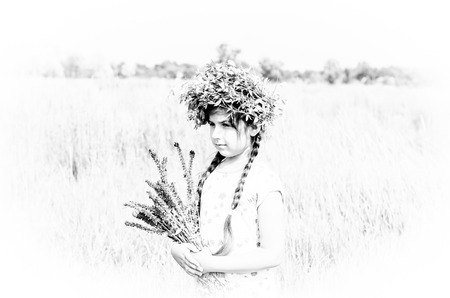 Vintage black and white photo of a girl with a bouquet in a fieldの写真素材