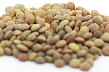Brown lentils detail photo on an isolated white background with strong defocus