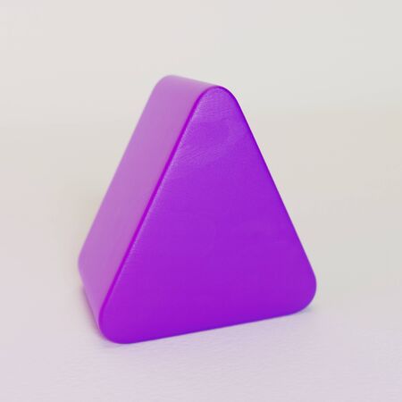 Purple plastic triangle shape toy block on white background. 3D illustration