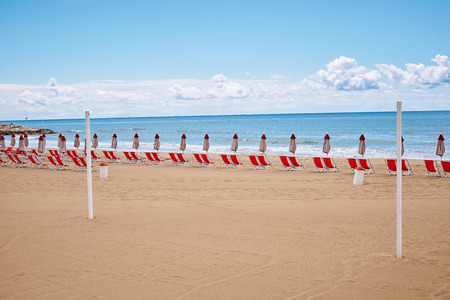 A beach with umbrellas and sun beds on coast of Terracina, Italyの写真素材