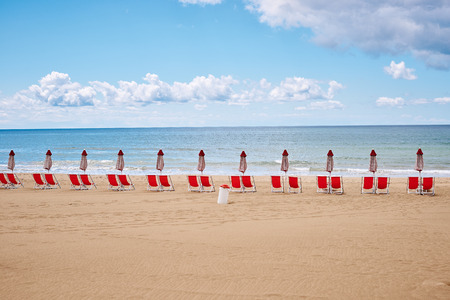 A beach with umbrellas and sun beds on coast of Terracina, Italyの写真素材