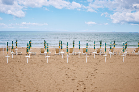 A beach with umbrellas and sun beds on coast of Terracina, Italyの写真素材