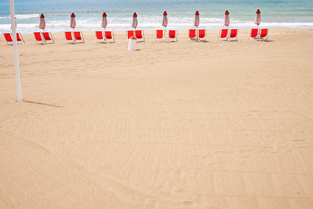 A beach with umbrellas and sun beds on coast of Terracina, Italyの写真素材