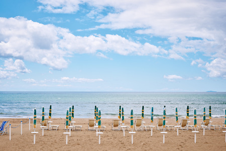 A beach with umbrellas and sun beds on coast of Terracina, Italyの写真素材