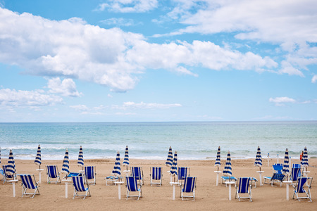 A beach with umbrellas and sun beds on coast of Terracina, Italyの写真素材