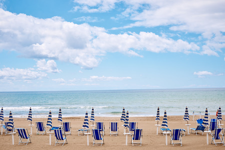 A beach with umbrellas and sun beds on coast of Terracina, Italyの写真素材
