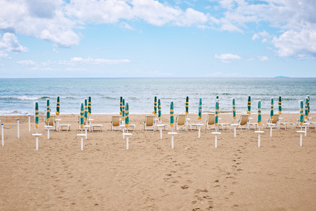 A beach with umbrellas and sun beds on coast of Terracina, Italyの写真素材