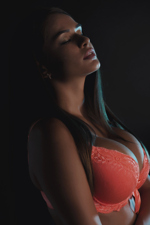 Slim woman in lingerie posing in the shadowsの写真素材