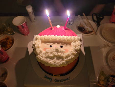 A birthday cake with a picture of Santa Claus and a candle.の写真素材