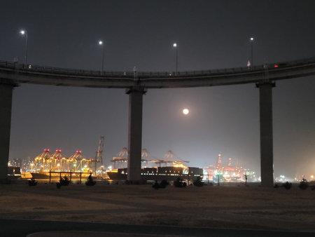 Night view of the highway under the bridge with the moon in the backgroundの写真素材