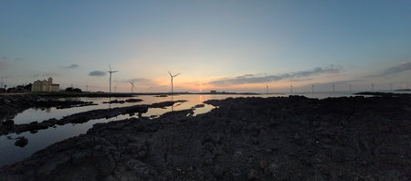 Sunset over the sea with wind turbines in the background, panoramaの写真素材