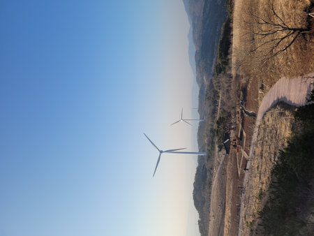 wind turbines on the top of a cliff in the mountains, blue sky