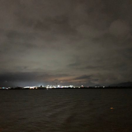 Night sky with clouds over the sea. Night view of the city.の写真素材