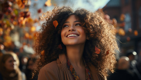 Beautiful african american woman with curly hair enjoying autumn day.の素材