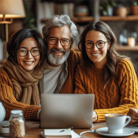 Portrait of happy mature couple in eyeglasses using laptop and smiling at camera while spending time together at home,Generative AIの素材