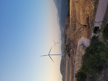 Wind turbines in the mountains at sunset. The concept of clean energy.の写真素材