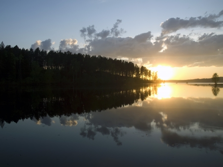 Sunset on the calm forest lake with reflections の写真素材