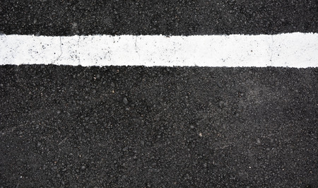 Strip of white paint on the asphalt road