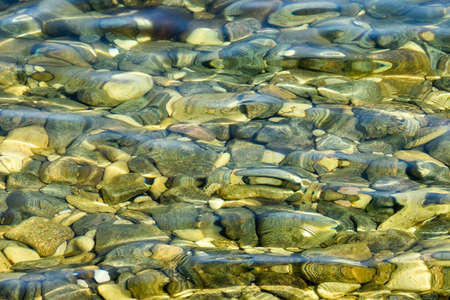 Crystal clear water with stones as a background