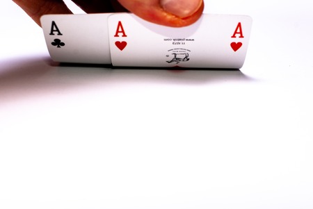Looking under covered cards showing two aces on white background