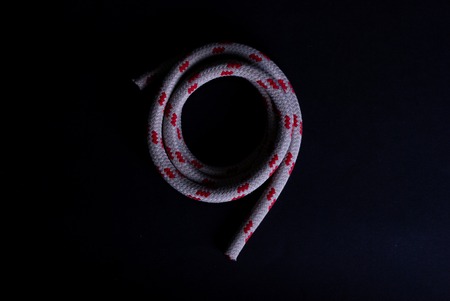 Top view of a red and white sailing rope on black background
