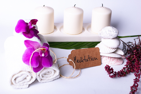 A set up of wellness items, towels, a bamboo mat, a shell, candles, a branch, wood, a starfishの写真素材