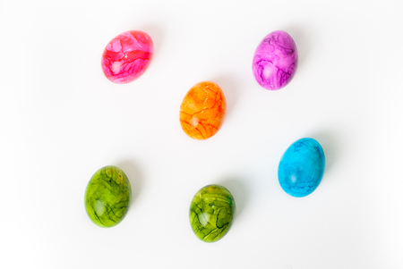 Flat lay of colorful painted easter eggs laying on white backgroundの写真素材